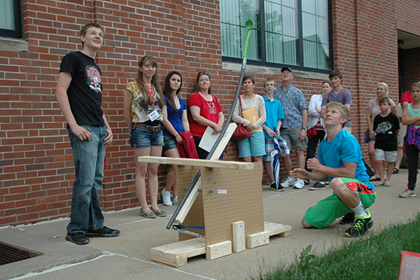 Using a spring-loaded catapult, a three-person team launches its ball.